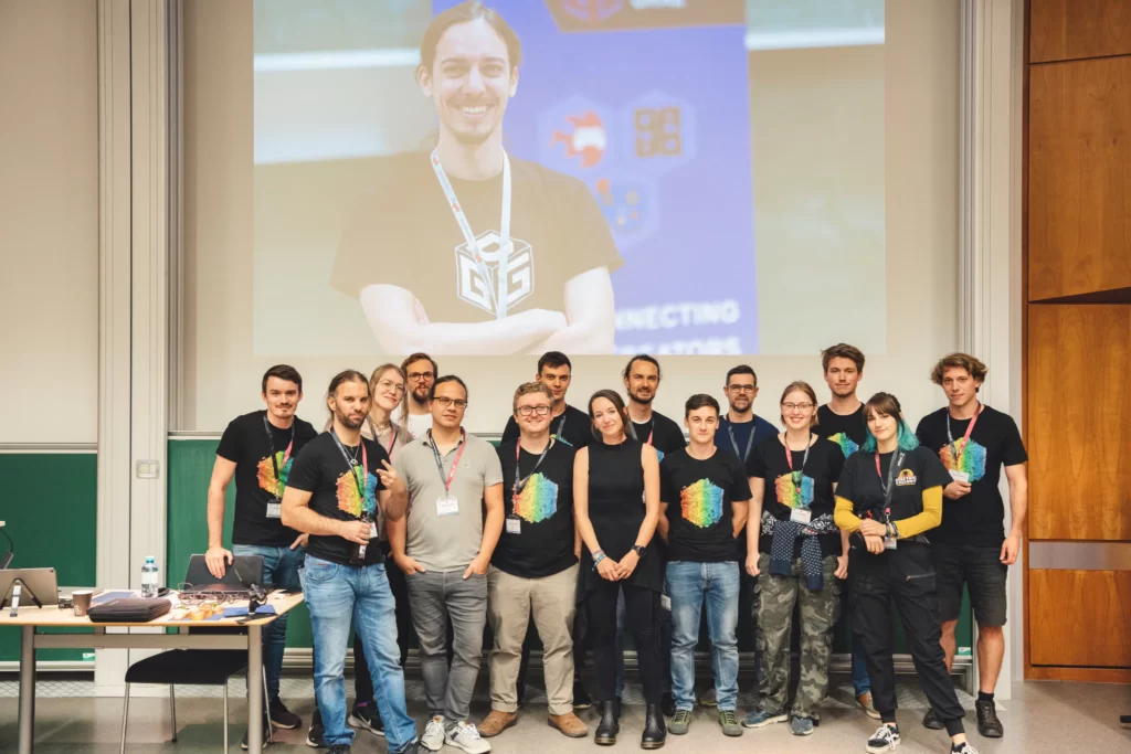 The Game Dev Days Graz team at the 2023 event, standing in front of the stage screen