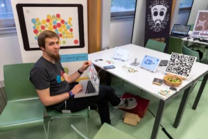 A developer showing his game at an exhibition table, Game Dev Days Graz 2018