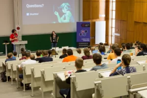 Johanna Pirker on stage with a Questions? slide at Game Dev Days Graz 2016
